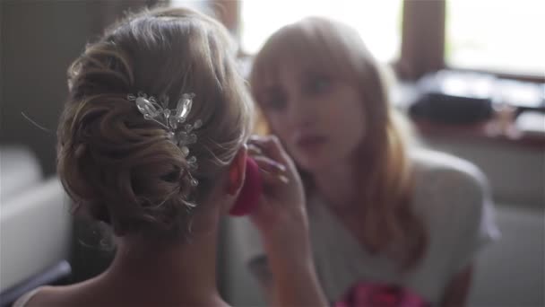 Maquilleur appliquer ombre à paupières avec pinceau pour faire face de près. Travail professionnel de maquillage de mariage à la maison ou salon de beauté vue arrière flou méconnaissable exposition à la lumière blanc vidéo shoot HD — Video