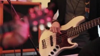 Bas gitar rock müzik yakın odak vardiya elektro gitar perde kuruluna kadar akorları basmak parmakları ile oynamak. Rock grunge çocuklar grubu balo ya da konser konser kulüpte heyecanla gerçekleştirme aşamasında