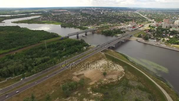 Survolez les voitures se déplaçant sur le pont routier à Homel Biélorussie vue aérienne 4K HD. Drone vol au-dessus de la rivière Sozh remblai, transport routier génie urbain Europe de l'Est post-soviétique architecture — Video