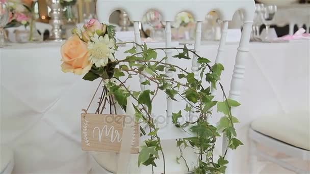 Yeşil Düğün dekor alımı için sandalyeye kapatın. Çiçek buketi ve vahşi Ivy dal dekorasyon, beyaz sandalye konuk koltuk alanı içinde düzenlenmiş olarak kullanılır. Düğün planı Çiçekçi Çiçek öğeleri karar çalışmak — Stok video