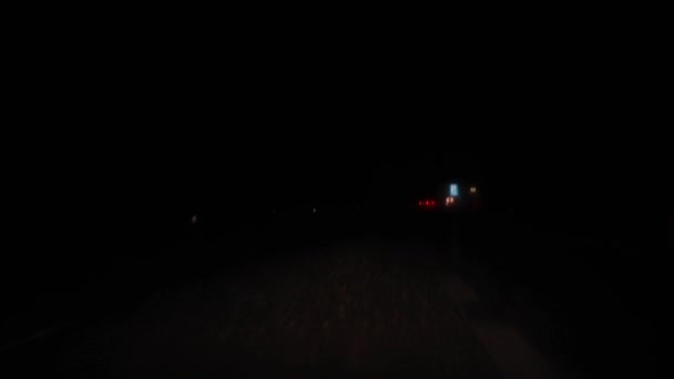Οδήγηση τη νύχτα δρόμο σε άσχημες καιρικές συνθήκες βροχής και χαμηλή ορατότητα πλησιάζει πάρκινγκ με σημάδια για τους οδηγούς φορτηγών να σταματήσει για να ξεκουραστούν από τις ώρες εργασίας. Θέα από το εσωτερικό καμπίνα στο παρμπρίζ — Αρχείο Βίντεο