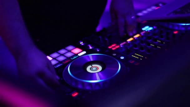 DJ spelen mix muziek draaitafel dek met kleuren licht handen close-up van slow-motion. Vinger beurt knoppen drukt u op de pads op midi controller raster professionele mixer functie console launchpad Zoek spoor in laptop — Stockvideo