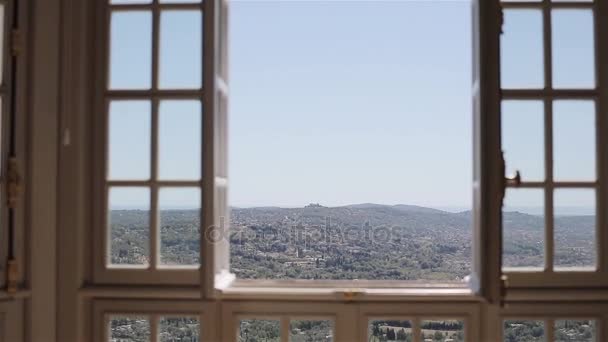 Vista panorámica de la ciudad del valle italiano o francés desde la ventana abierta. Colinas verdes paisaje y techos de la Riviera Francesa Grasse en Europa desde villa en la cima de la montaña. Aire fresco del campo en el cielo concepto — Vídeo de stock