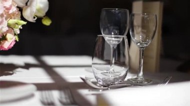 Stemware ve çatal tablo ışık makro yakın çekim. Su ve şarap çiçek buketi beyaz masa örtüsü üzerinde yakın gözlük. Gıda ve İçecek sanayi evlilik yıldönümü catering bakım Ziyafet