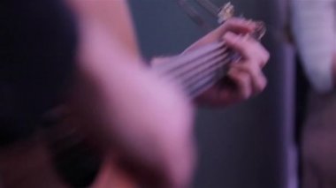 Akustik Gitar akorları fretboard üzerinde basarak parmak makro raf odak kadar yakın el oynayın. Müzisyen vasıl geçmiş çalışma fotoğrafçı ile ülke şarkı koparma dizeleri komedi kulübü etkinliği gerçekleştirir