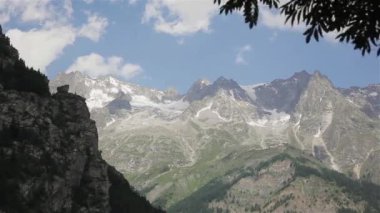 Mont Blanc Dağı massif Vadisi üzerinde üst bulutlar gökyüzü rüzgarlı küçük kar görüntüleyin. Doğal yaz manzara buzul kaplı bahar şelale görüldü Kuzey İtalyan yan Courmayeur kasabadan, Aosta rotaları