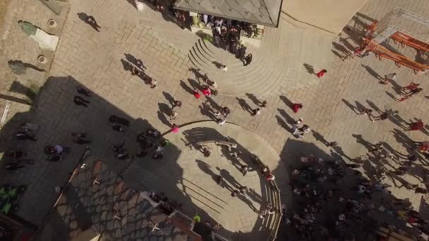 4k Multitud de personas se mueven en el viejo centro de la plaza europea desde arriba. El grupo de invitados del día del sol se para en la reunión de saludo de escaleras de la iglesia esperando un disparo de dron aéreo bajo. La vida de la pequeña ciudad medieval en Italia — Vídeos de Stock