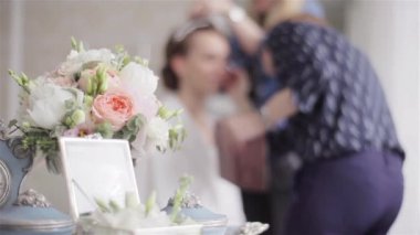 Masa saati ile ufuk arka plan ve buket dekorasyon photoshoot veya Güzellik Yarışması için hazırlanan modeli yakın odak içinde. Stilist ve makyaj ana çalışma birlikte takım. Zaman kavramı