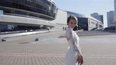 Beyaz elbiseli güzel kadın kamera iş bölgesi sokak kentsel arka plan gülümseyen bakarak poz durumda. Genç seksi model zevk düğün dantel elbise yaz güneşi giyiyor. Gelin Moda atelier