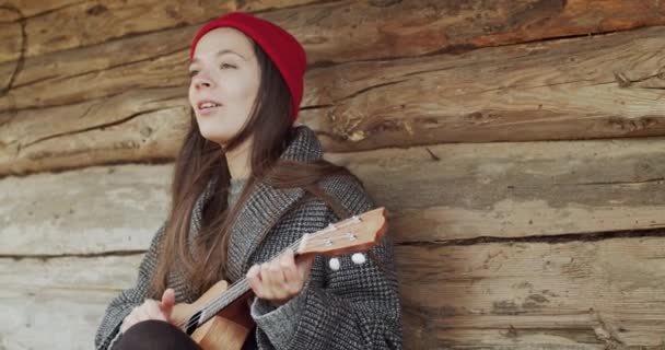Vacker Kvinnlig Musiker Sjunga Och Spela Ukulele Utomhus Timmerstuga Bakgrund — Stockvideo