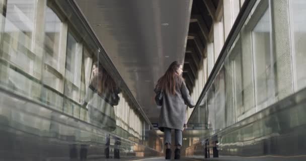 年轻女子站在走道上慢慢地倒影 女旅行家乘坐旅行车离开室内自然光 旅行公务旅行的概念 — 图库视频影像