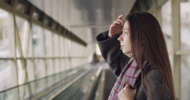 Stylowa Młoda Dama Dopasowująca Długie Włosy Stojąc Samotnie Szklanym Tunelu — Wideo stockowe