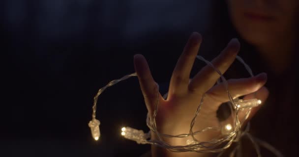 Weibliche Hand Mit Leuchtdiodenlampengirlande Großaufnahme Freien Auf Schwarzem Hintergrund Gesichtslose — Stockvideo