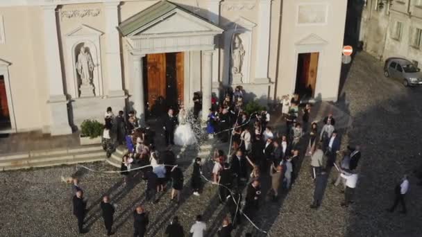 Vrchní letecký pohled na nově oddaný pár stojící u starověké katedrály na svatebním obřadu. — Stock video