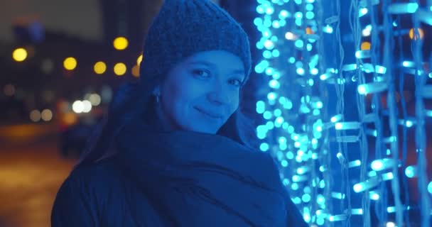 여자가 겨울옷을 불빛으로 도시의 거리에 여성은 움직임을 보였습니다 축일의 — 비디오