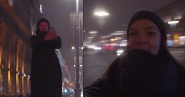 Elinde akıllı telefonuyla selfie çeken gülümseyen bir kızın çift portresi. Gece şehrinin arka planında dönen iki mutlu kadın çekimi yavaş çekimde yakınlaşıyor. Mutluluk teknolojileri