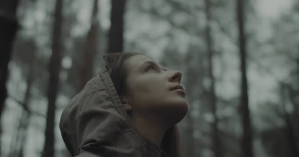 Nahaufnahme Porträt eines jungen Mädchens steht im Wald und hört den Vögeln und der Natur zu. Schöne Frau, die nachdenkt, in den Himmel blickt und am Abend betet. Einheit mit der Natur und Glück — Stockvideo