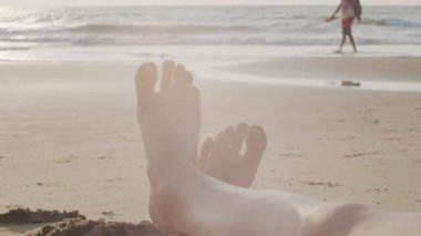 Güneşli kumsal arka planında çıplak ayakla kadın fotokopi makinesini kapat. Sahil şeridinde okyanus dalgalarıyla deniz kenarında dinlenen çıplak ayaklı kadın. Yüksek anahtarlı tatil duvar kağıdı
