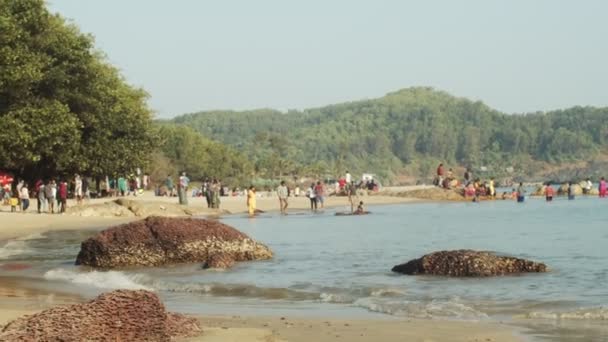Неузнаваемые люди отдыхают на берегу реки на зеленом индийском ландшафтном фоне. Видеосъемка обычного дневного образа жизни в сельской Индии замедленной съемки. Жизненные привычки путешествуют подлинностью. Летний отдых — стоковое видео