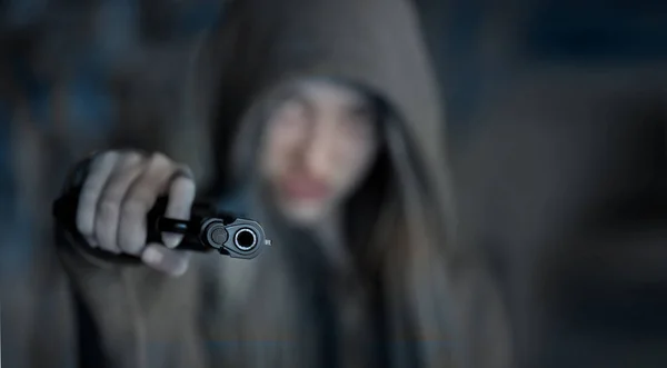 十几岁的女孩瞄准枪对着相机，模糊焦点 — 图库照片