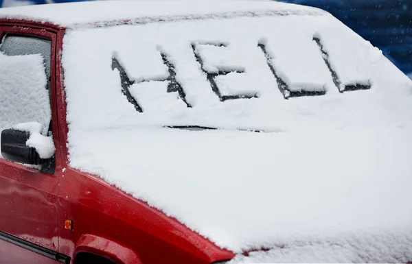 "地狱"一词写在冰雪覆盖的汽车挡风玻璃上 — 图库照片