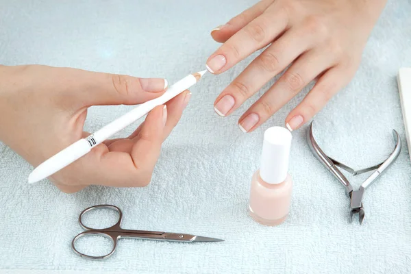 Kvinna att göra manikyr med nailfile med nail care verktyg backg — Stockfoto