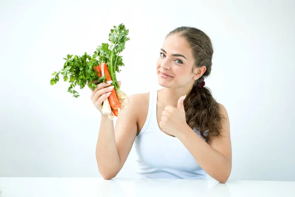 Schöne junge Frau mit gesundem Essen in der Hand am Licht — Stockfoto