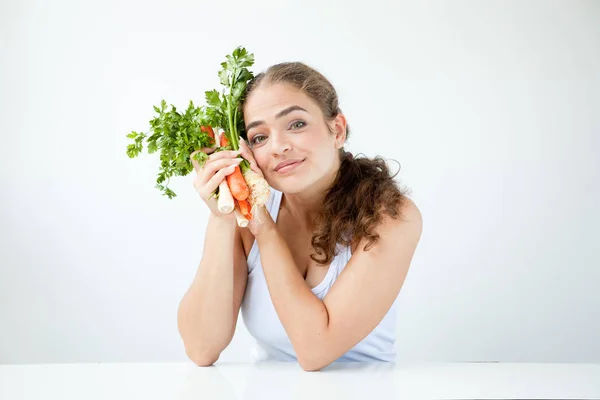 Schöne junge Frau mit gesundem Essen in der Hand am Licht — Stockfoto