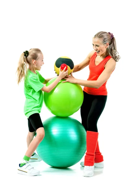 Mujer joven y la chica de fitness en una gran bola — Foto de Stock
