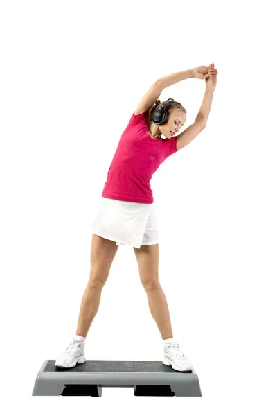 Femeia tânără care poartă căști se întinde până în partea de sus a unui fitness — Fotografie, imagine de stoc