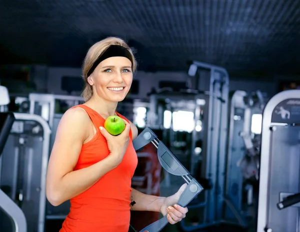 A young woman holding a scales and an apple in her hands. It's i — Stock Photo, Image