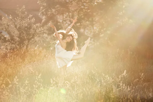 Belle jeune femme dansant au soleil dans la nature — Photo