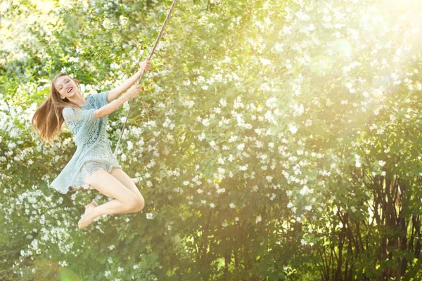 Veselé. Krásná dívka v parku na houpačce houpal. V su — Stock fotografie