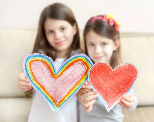 Two little girls (5 - 7 years old ) give painted hearts. Father' — Stock Photo, Image