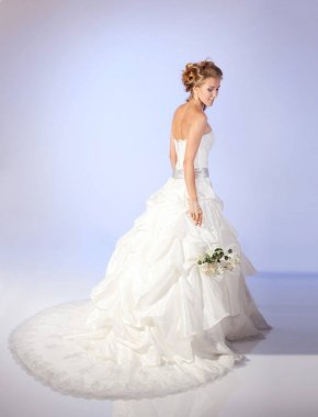 Bir buket çiçek üzerinde hafif bir adam tutarak büyüleyici gelin