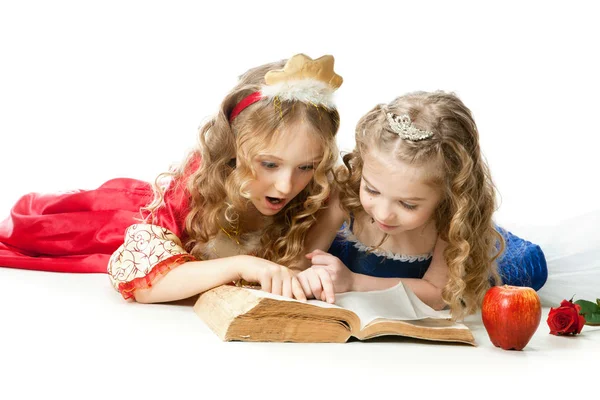 Deux charmantes petites princesses lisant le livre magique — Photo