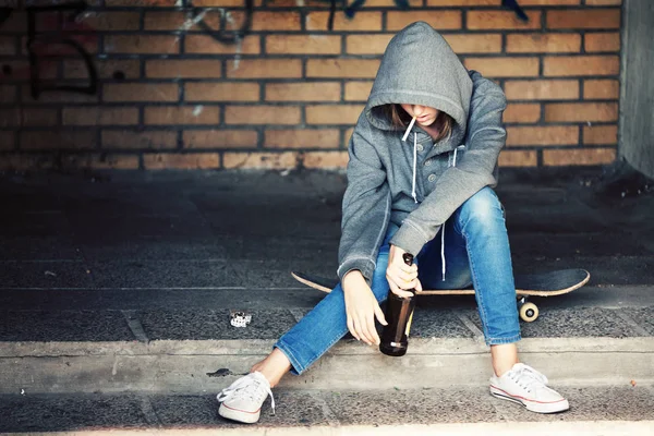 Bira ve sigara ile oturan yalnız genç kız