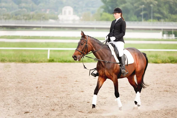 Attraktive junge Frau im Jockey-Anzug reitet Pferd — Stockfoto