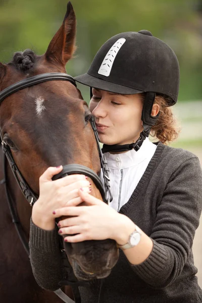 Attraente giovane donna abbracciare e baciare il suo cavallo — Foto Stock