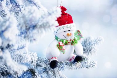 Bir kar ağaç dalına asılı Noel kardan adam