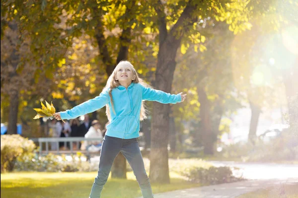 Niña levantando sus brazos y disfrutando del soleado día de otoño —  Fotos de Stock