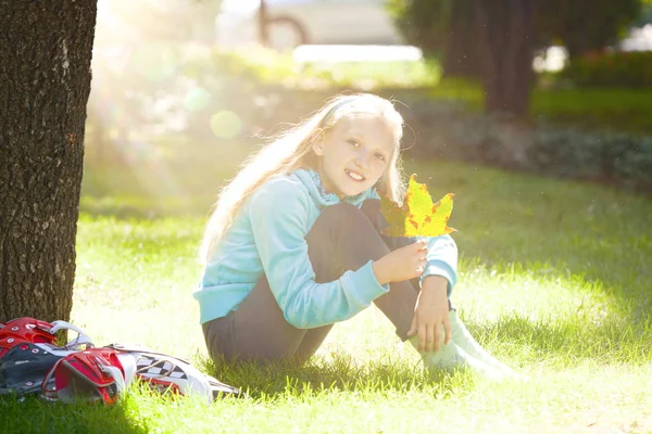 Silindirler ile oturan ve güneşli bir sonbahar gün zevk küçük kız — Stok fotoğraf