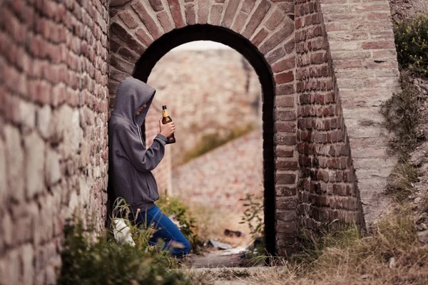 Menina adolescente solitária bebendo cerveja no portão — Fotografia de Stock