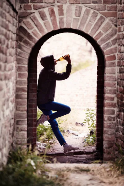 Menina adolescente solitária bebendo cerveja no portão — Fotografia de Stock