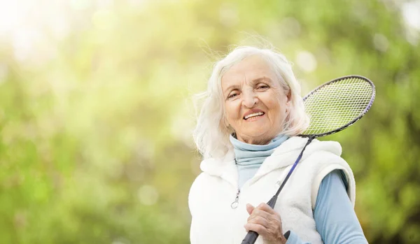 Starší žena hraje tenis venku — Stock fotografie