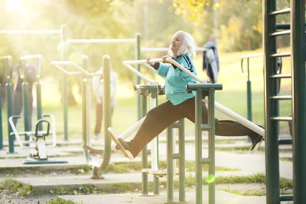 Старшая женщина делает упражнения на открытом воздухе — стоковое фото