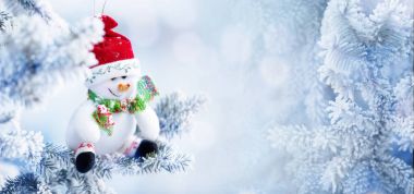 Bir kar ağaç dalına asılı Noel kardan adam