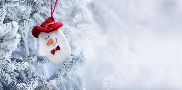 Natal boneco de neve meia pendurado em um ramo de árvore de neve — Fotografia de Stock