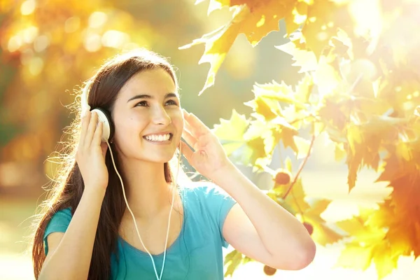 Ευτυχισμένος κορίτσι ακούτε τα ακουστικά σε μια υπέροχη μέρα του φθινοπώρου — Φωτογραφία Αρχείου