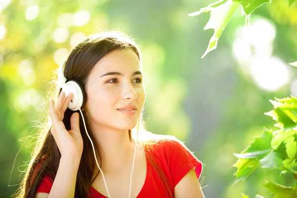 Ευτυχισμένος κορίτσι που ακούει με ακουστικά μια υπέροχη καλοκαιρινή μέρα — Φωτογραφία Αρχείου